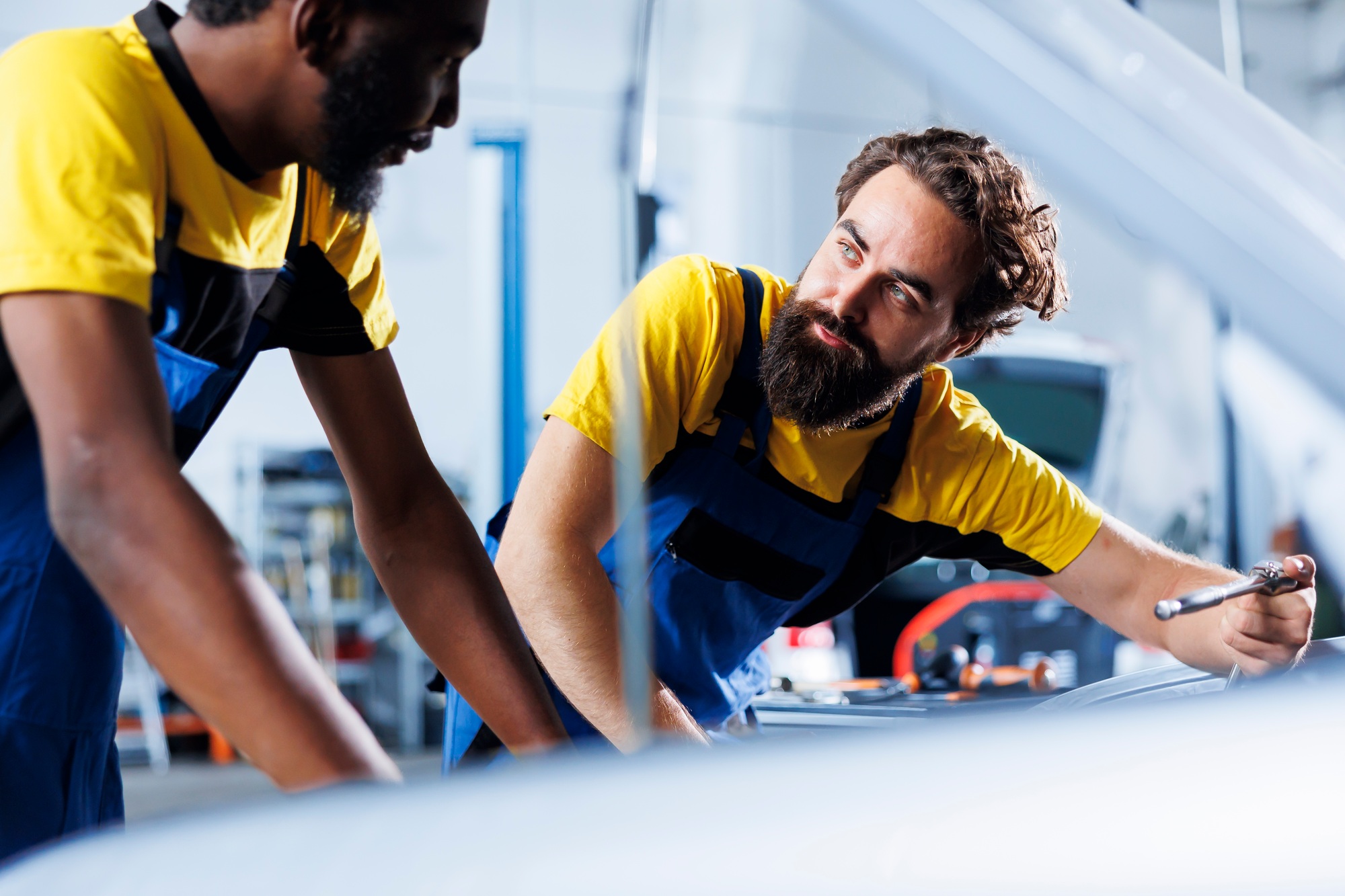 Technicians in garage fixing damaged car